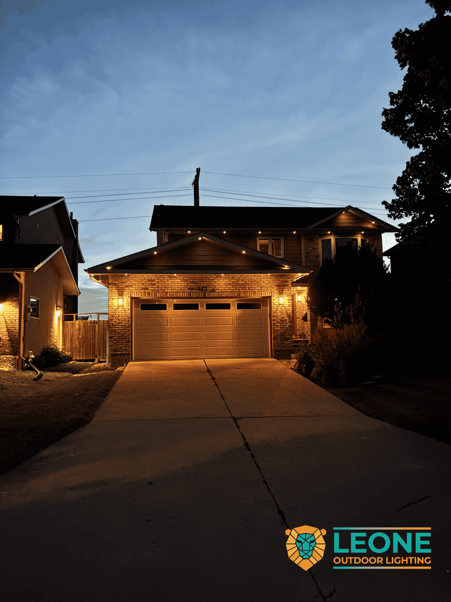 Warm white permanent holiday lights on Winnipeg bungalow with lit garage and entry