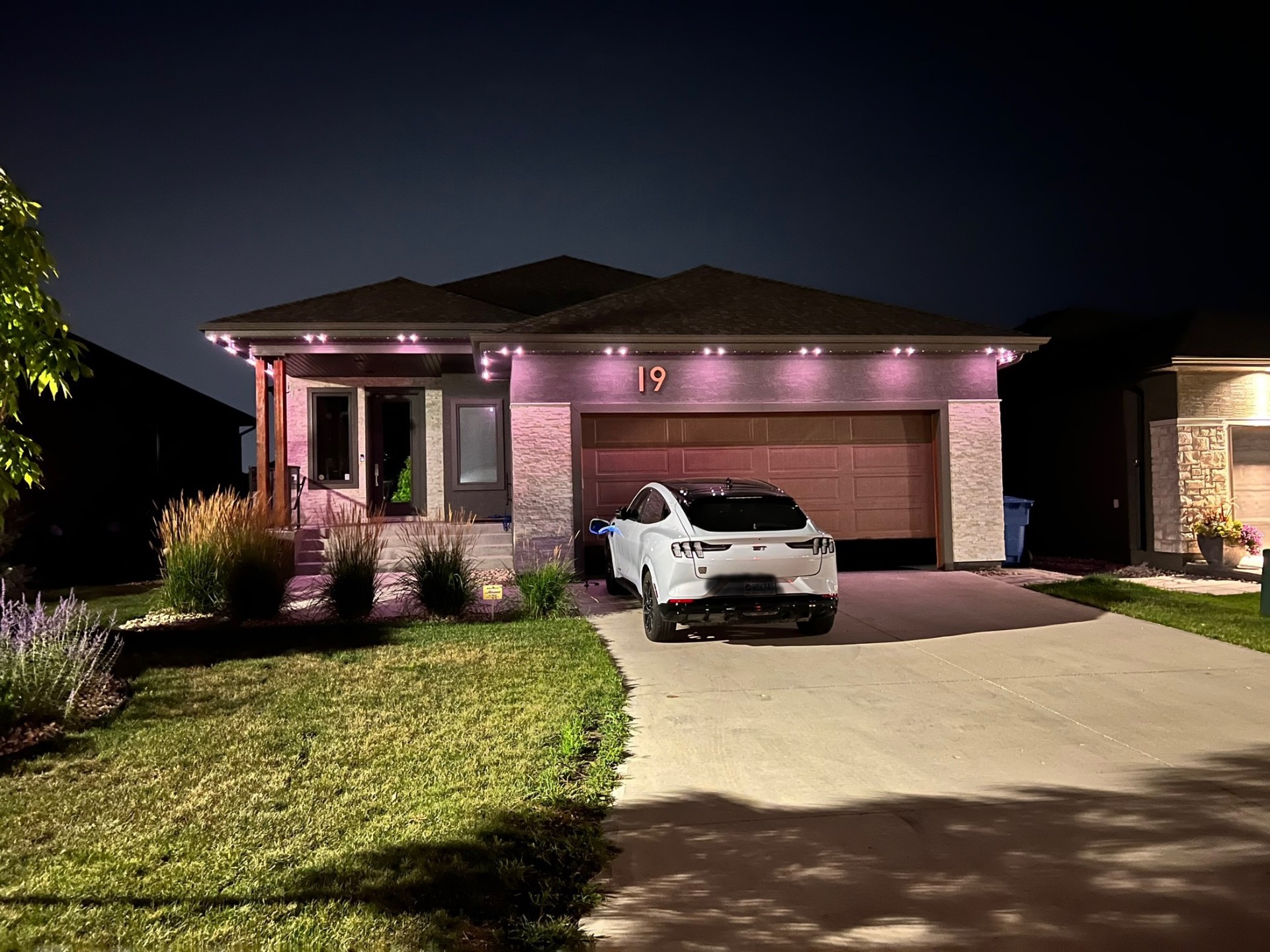 Permanent LED holiday lighting with pink uplighting on Winnipeg home