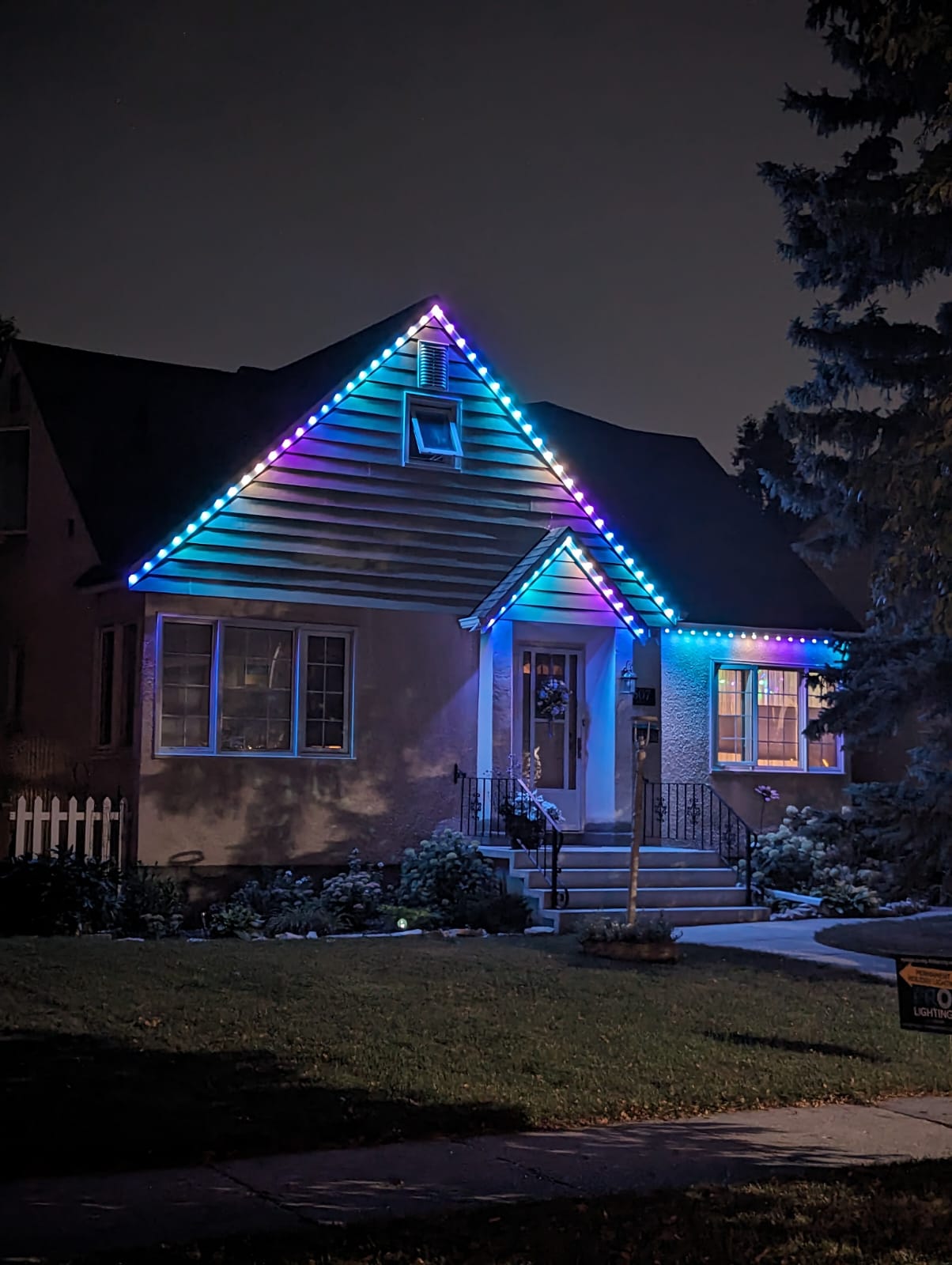 Blue and purple permanent roofline lighting on Manitoba bungalow