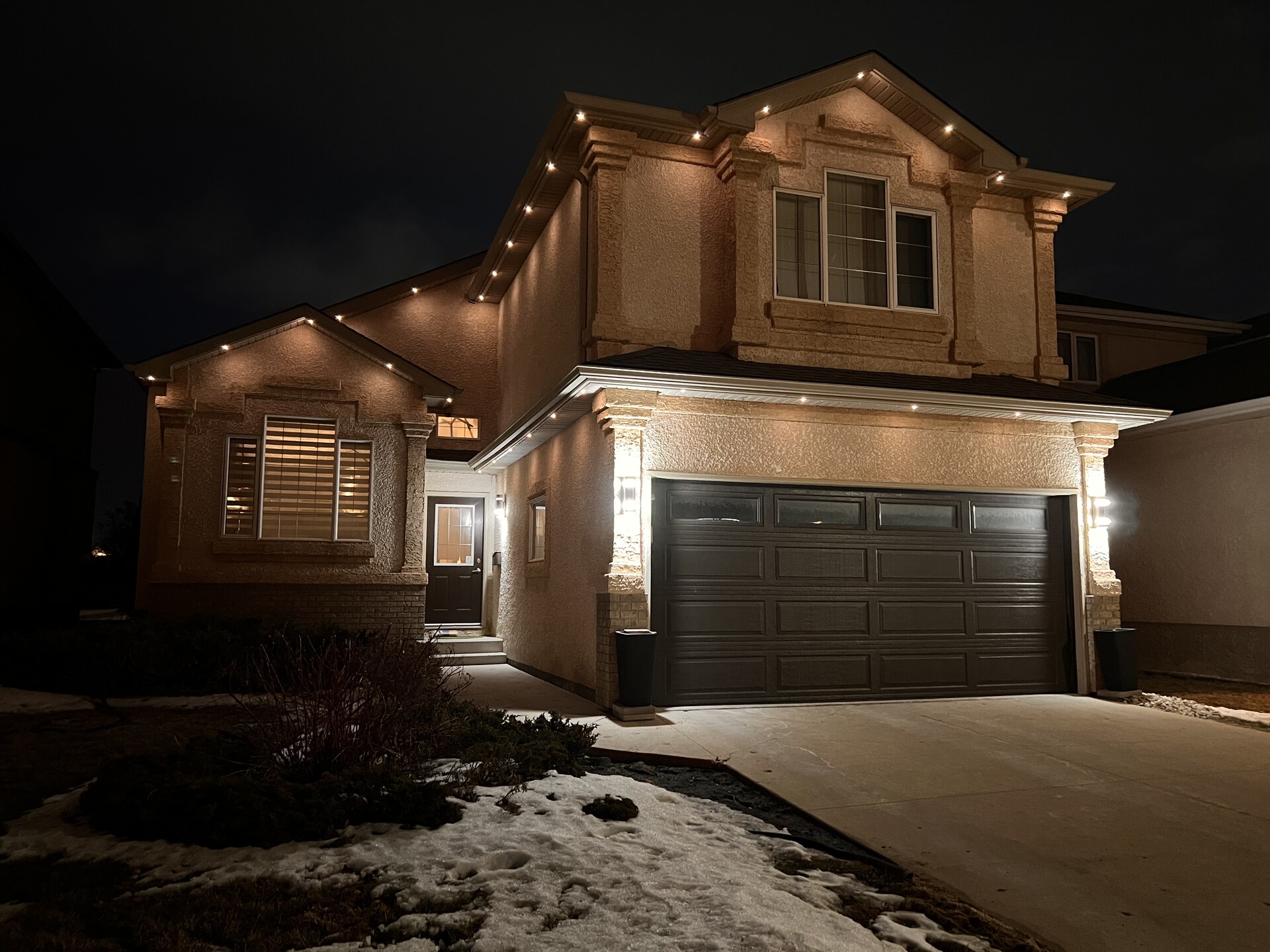 Warm white soffit lighting highlighting stucco architecture